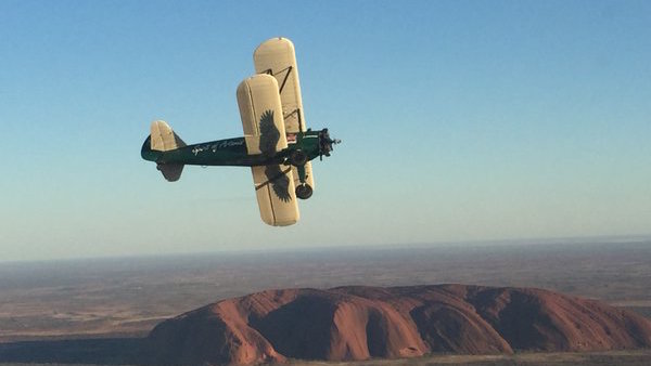 El Boeing Stearman, sobrevolando la famosa roca de kevin Ayer, en Australia